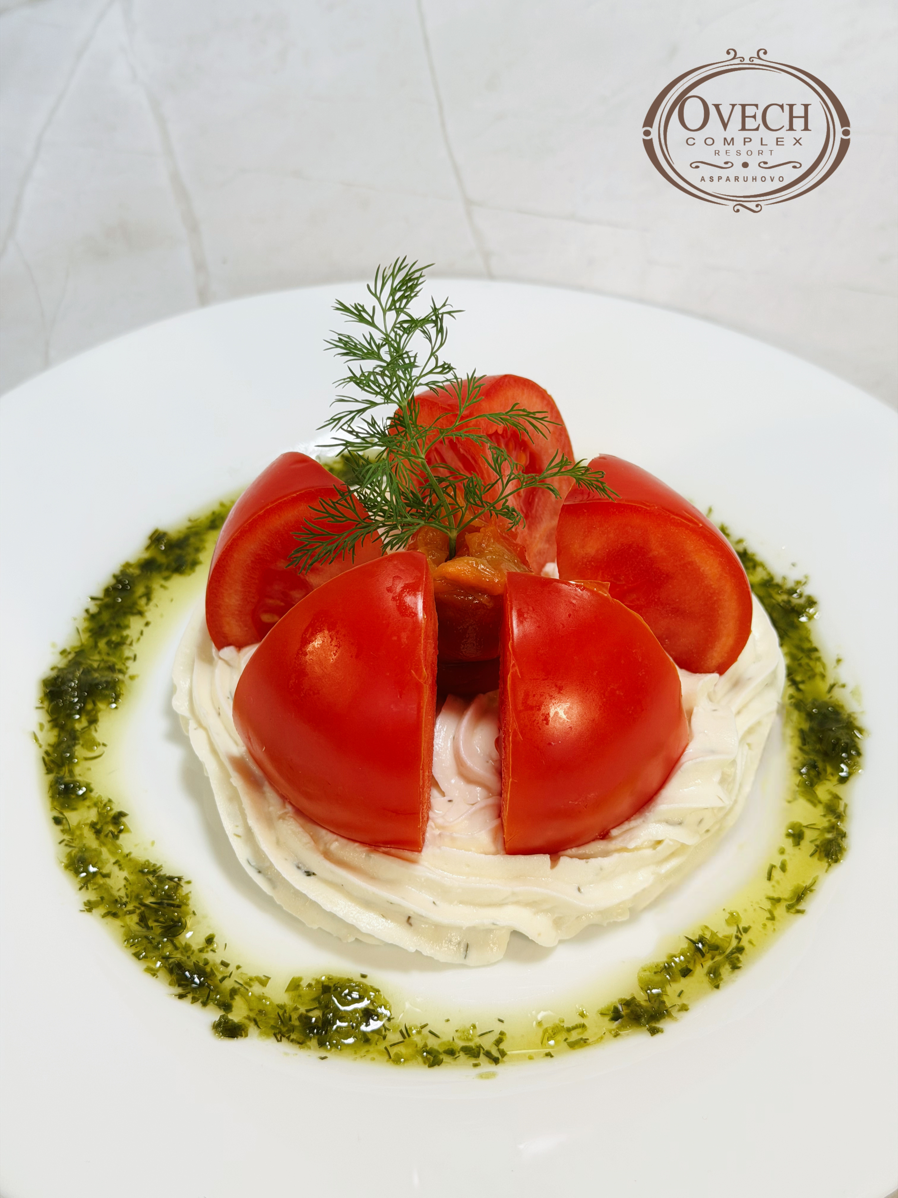 Tomato and herbs plated on white porcelain