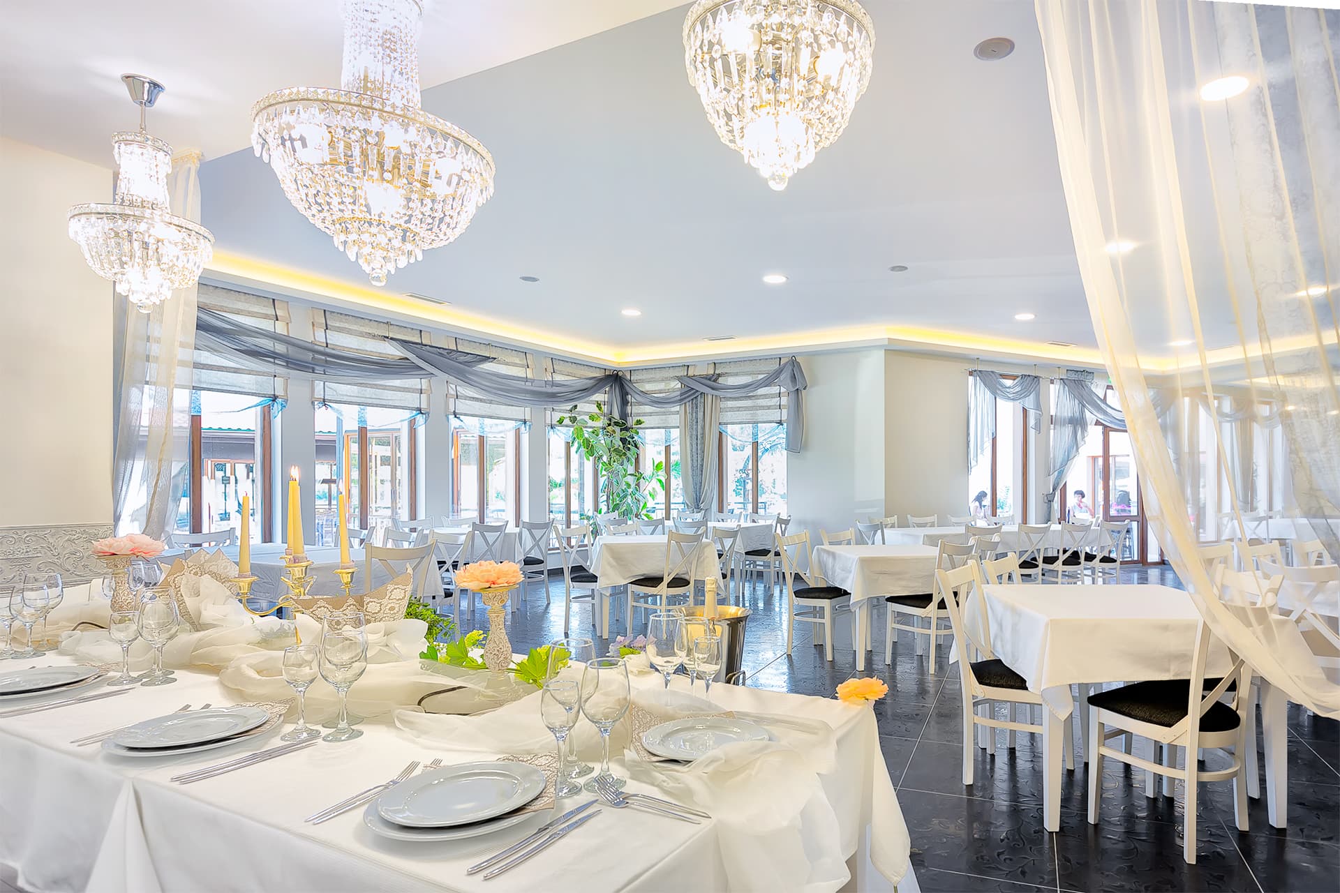 The main restaurant with chandeliers and tables laid for guests